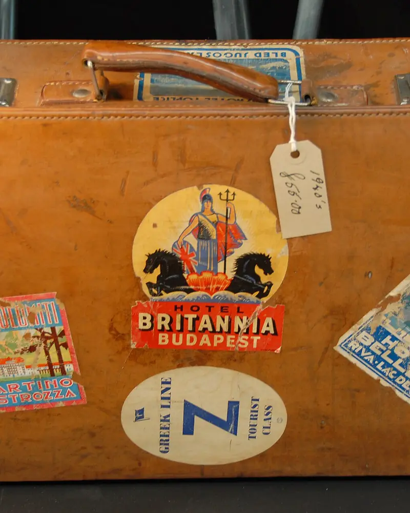 Maleta de cuero llena de etiquetas de viaje pegadas