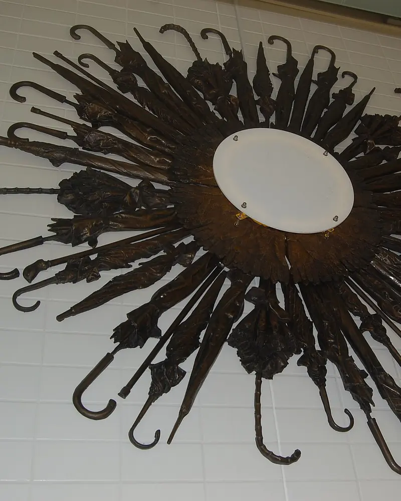Escultura hecha con paraguas olvidados colgada en una pared